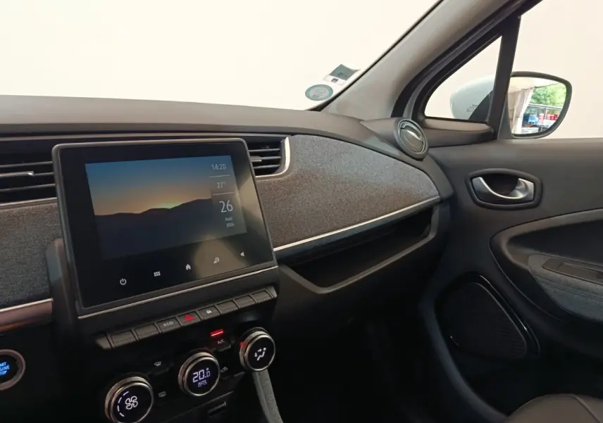 Intérieur de la Renault ZOE Intens blanc, vue côté passager sur tableau de bord avec écran tactile central.