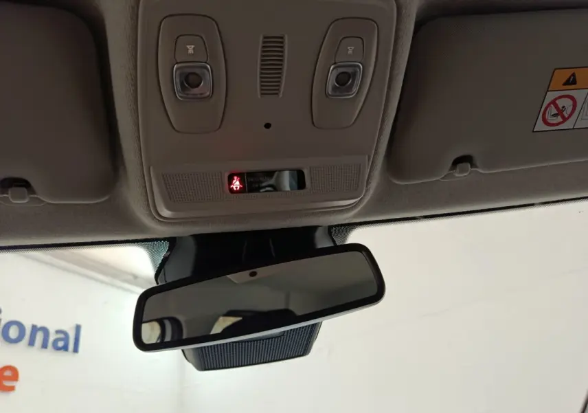 Vue intérieure du rétroviseur central et du plafonnier beige avec éclairages et témoin d'airbag passager allumé.