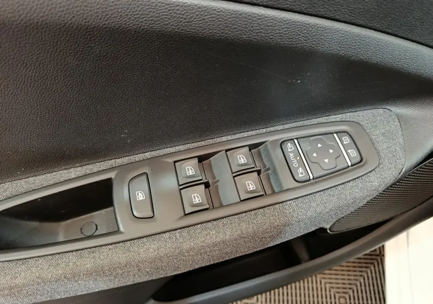 Détail des commandes des vitres et rétroviseurs sur la porte côté conducteur d’une Renault ZOE blanche Intens R110 2021.