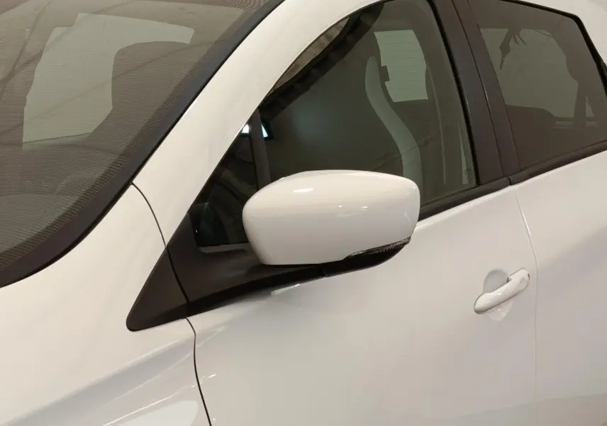 Gros plan sur la porte avant gauche blanche d’une Renault ZOE Intens R110 avec rétroviseur blanc et poignée intégrée.