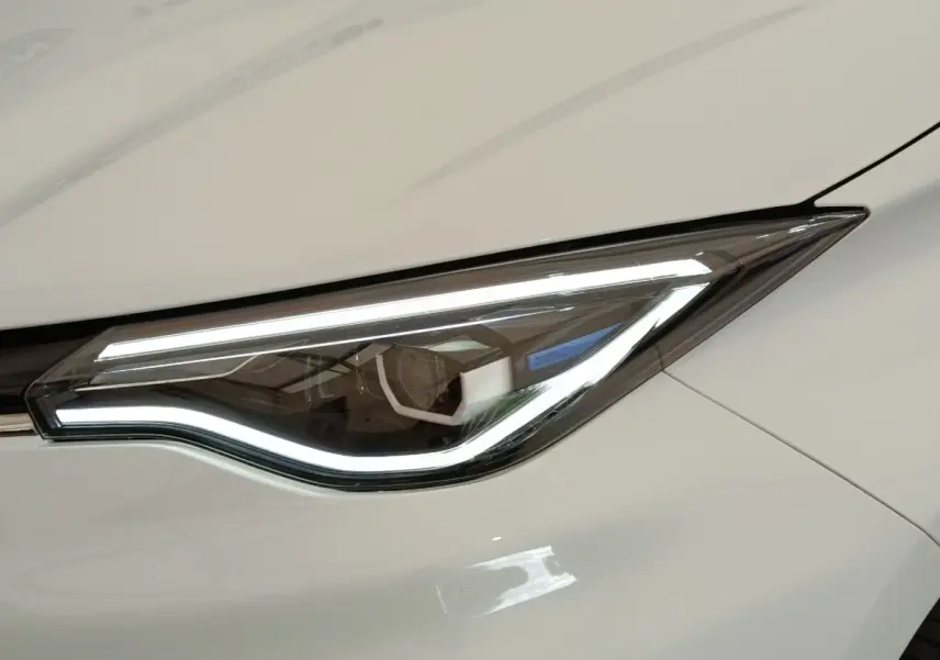 Gros plan sur le phare avant droit LED de la Renault ZOE Intens R110 blanc, soulignant son design moderne et élégant.
