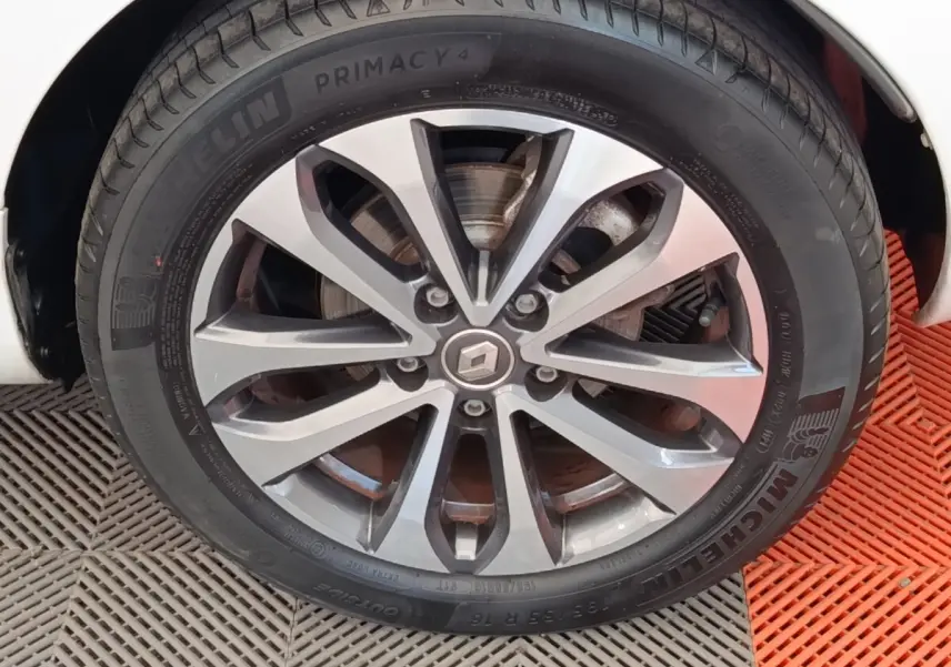 Gros plan sur la roue avant droite d'une Renault ZOE blanche, jante alliage à design moderne et pneu Michelin.