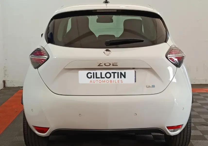 Vue arrière d'une Renault ZOE blanche 2021 avec feux arrière distinctifs et logo ZOE centré sur le hayon.