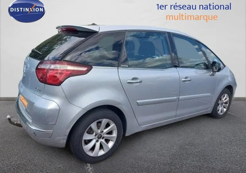 Vue côté droit arrière d'une Citroën C4 Picasso gris alu métal de 2013 avec attelage et jantes alliage.