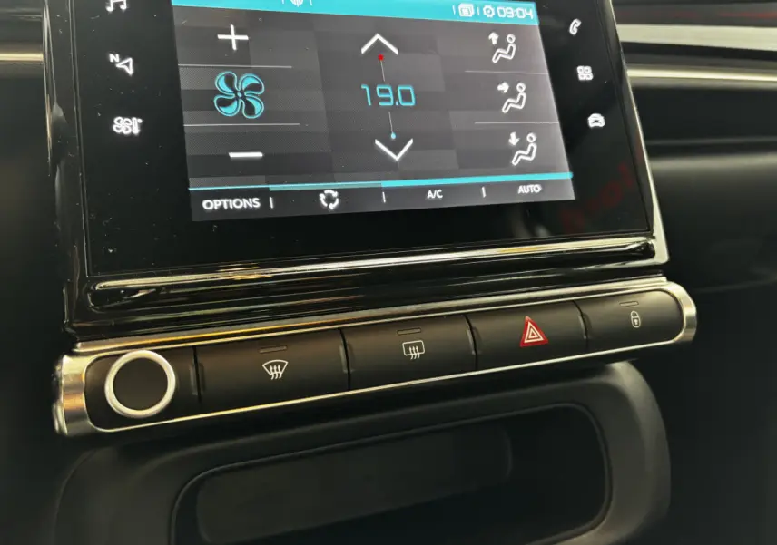 Gros plan sur l'écran tactile central et les commandes de climatisation d'une Citroën C3 gris foncé 2024.