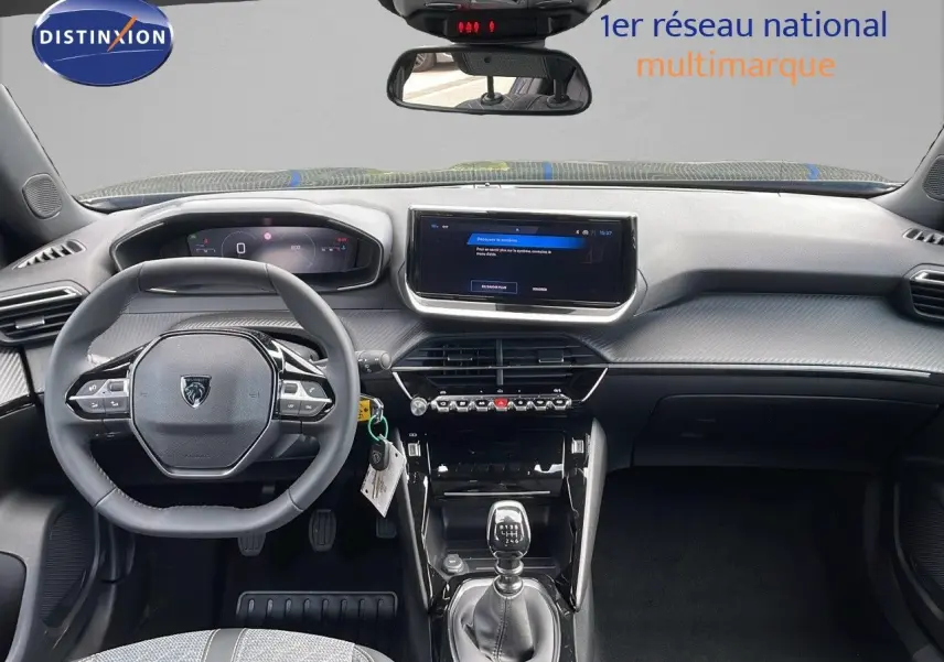 Intérieur de la Peugeot 2008 2025 noir perla metal, vue frontale du tableau de bord avec volant et boîte manuelle.