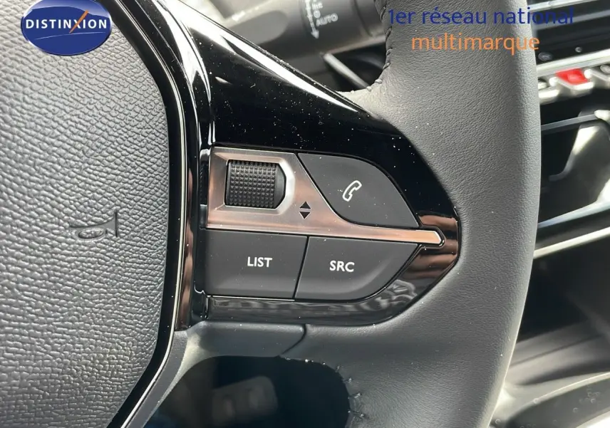 Gros plan sur les commandes gauche du volant cuir noir du Peugeot 2008 2025, avec boutons de contrôle audio et appel.