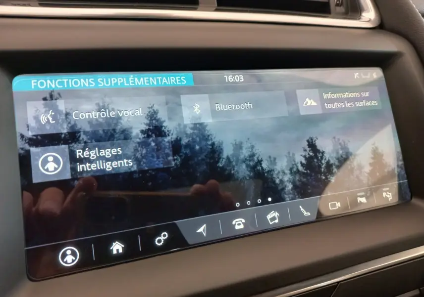 Écran tactile du tableau de bord du Jaguar E-PACE blanc 2019 affichant les fonctions vocales et Bluetooth.