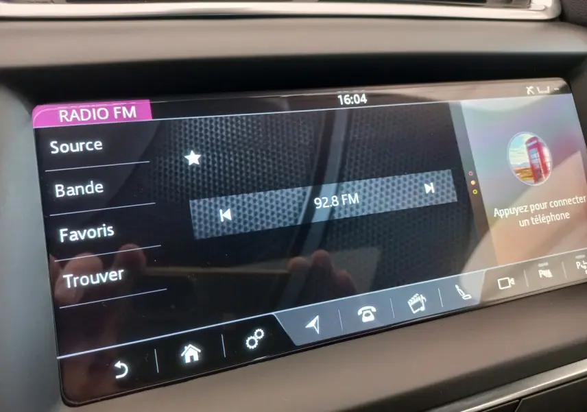 Écran tactile central de la Jaguar E-PACE blanc 2019 affichant la radio FM sur 92.8 MHz en intérieur.