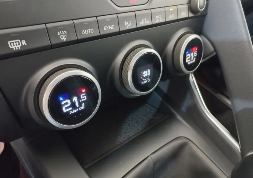Gros plan sur les commandes de climatisation digitale du tableau de bord du Jaguar E-PACE blanc, version D180 BVM AWD R-DYNAMIC S.