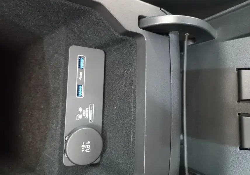 Gros plan sur la prise 12V et ports USB dans le rangement central du Jaguar E-PACE blanc de 2019.