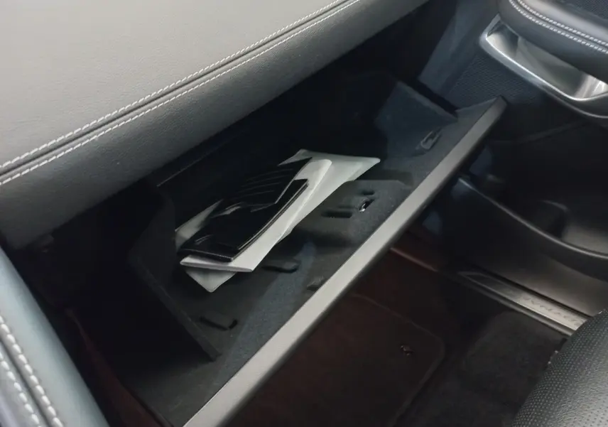 Gant de boîte à gants ouvert côté passager dans Jaguar E-PACE blanc, intérieur noir avec surpiqûres grises.