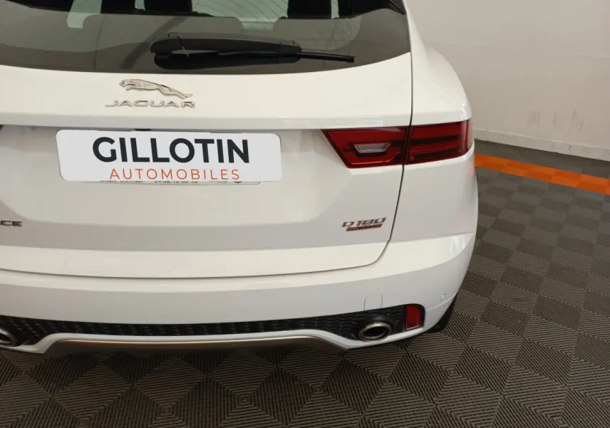 Vue arrière droite d'un Jaguar E-PACE blanc D180 Diesel avec feux LED et double sortie d'échappement visible.