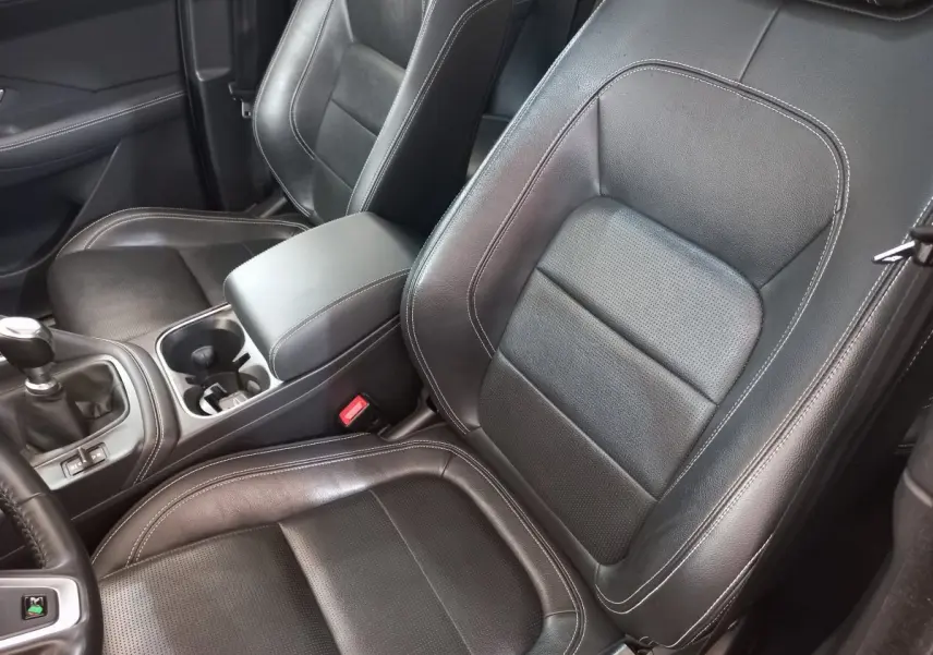 Vue rapprochée des sièges avant en cuir noir et console centrale d'une Jaguar E-PACE blanc 2019.