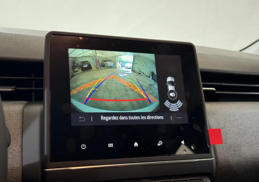 Écran tactile central montrant la caméra de recul avec lignes de guidage dans une Renault Clio gris clair 2025.