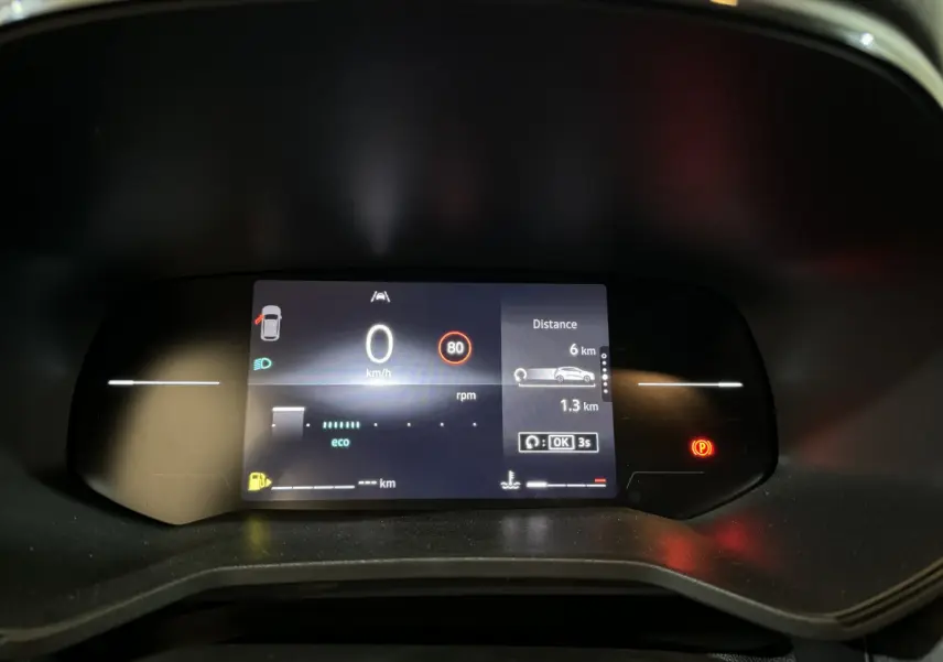 Combiné d'instruments numérique de la Renault Clio gris clair 2025 affichant vitesse, distance et alertes au tableau de bord.