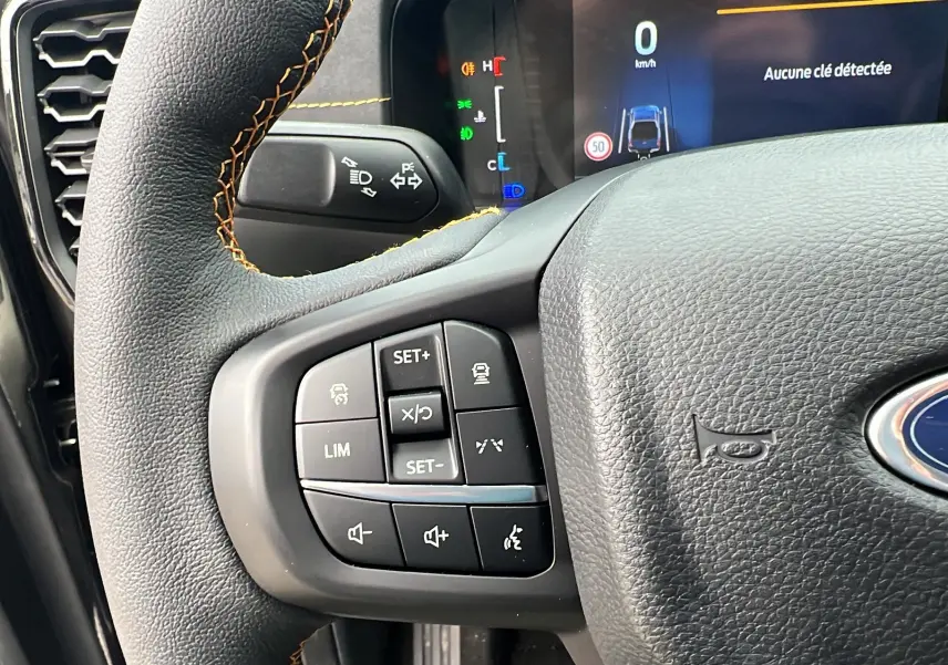 Gros plan sur le volant noir du Ford Ranger 2026 avec commandes multifonctions et tableau de bord digital visible.