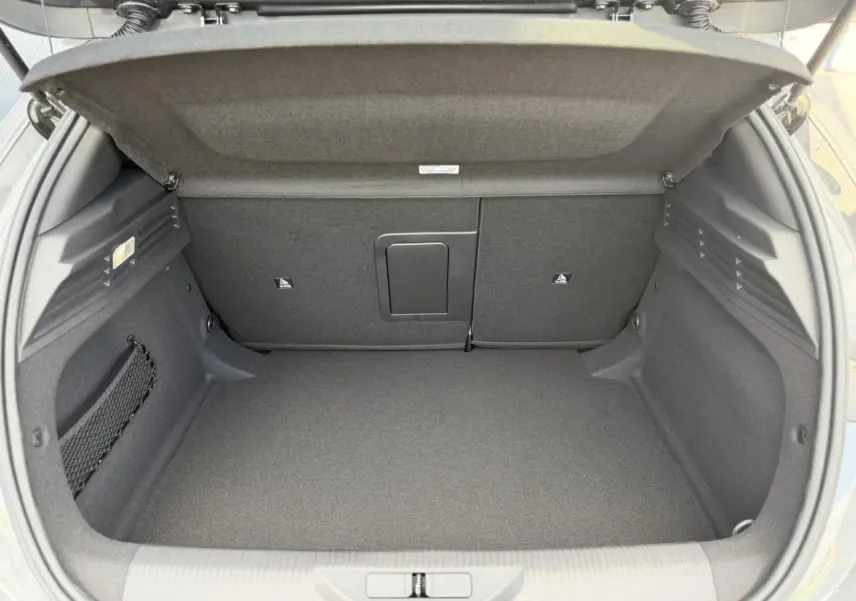 Coffre ouvert de la Peugeot 308 NV Hybrid 145 GT e-DSC6 gris Selenium, montrant un espace de chargement propre et bien agencé.