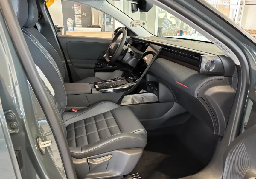 Vue intérieure côté passager avant du Citroën C5 Aircross vert, avec tableau de bord moderne et sièges noirs.
