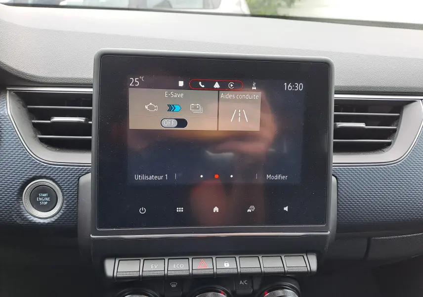 Écran tactile central du tableau de bord du Renault Arkana 2023 avec commandes climatisation et bouton start engine stop visible.