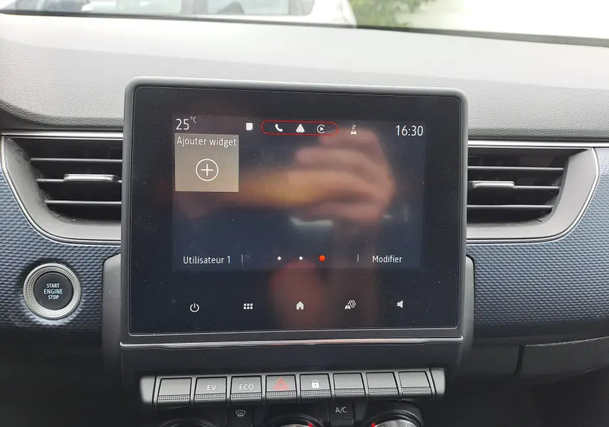 Écran tactile central du tableau de bord du Renault Arkana 2023 avec boutons de commande et finition bleu Zanzibar métal.