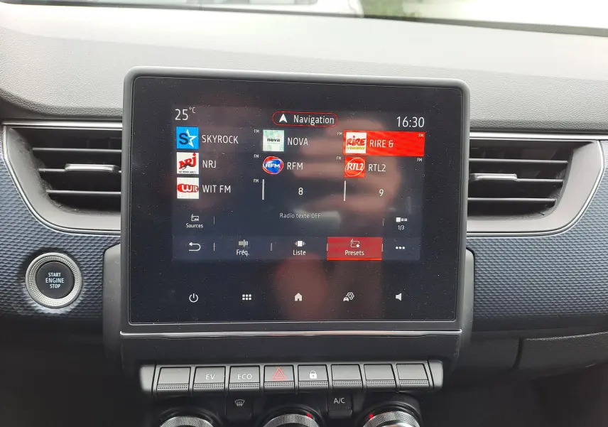 Écran tactile central du Renault Arkana 2023 affichant les stations radio, entouré de commandes et bouton start engine stop.