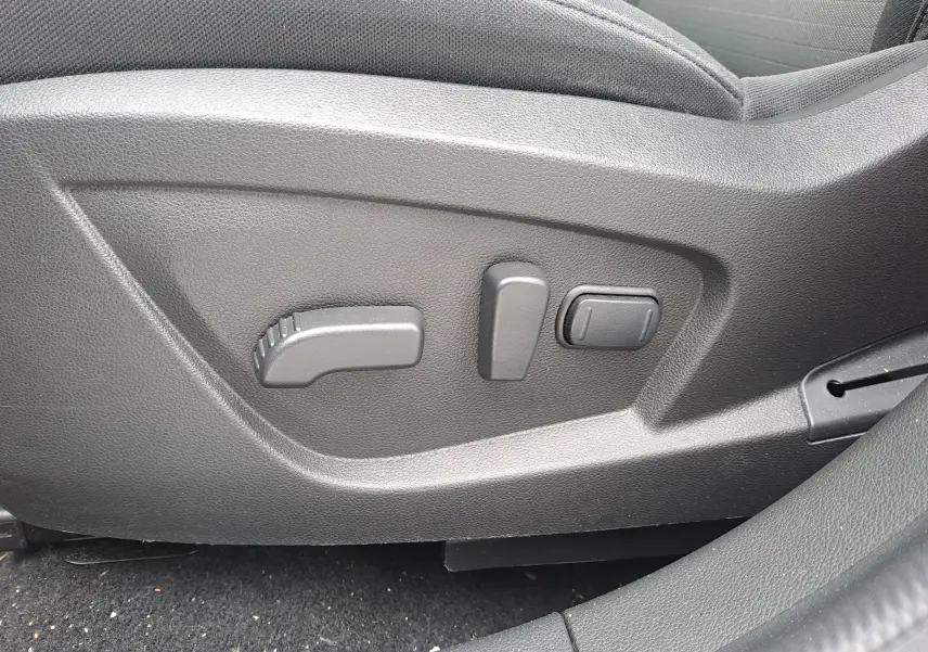 Commandes électriques de réglage du siège conducteur sur Renault Arkana bleu Zanzibar 2023, intérieur tissu noir.