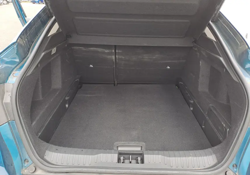 Coffre ouvert vu de l'arrière d'un Renault Arkana bleu Zanzibar Metal, montrant un espace de chargement propre et spacieux.