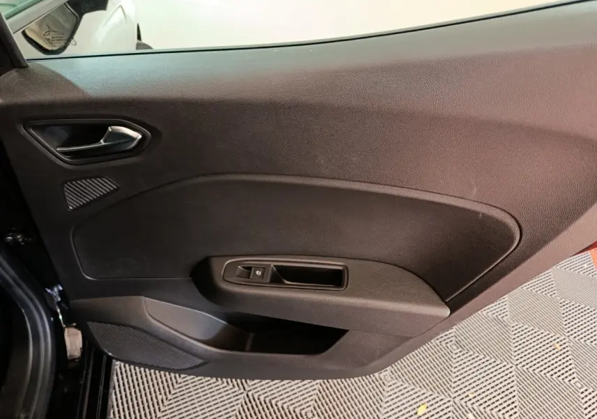 Intérieur côté gauche de la porte avant noire de la Renault Clio Evolution Blue dCi 100 -25, avec poignée et commande de vitre.