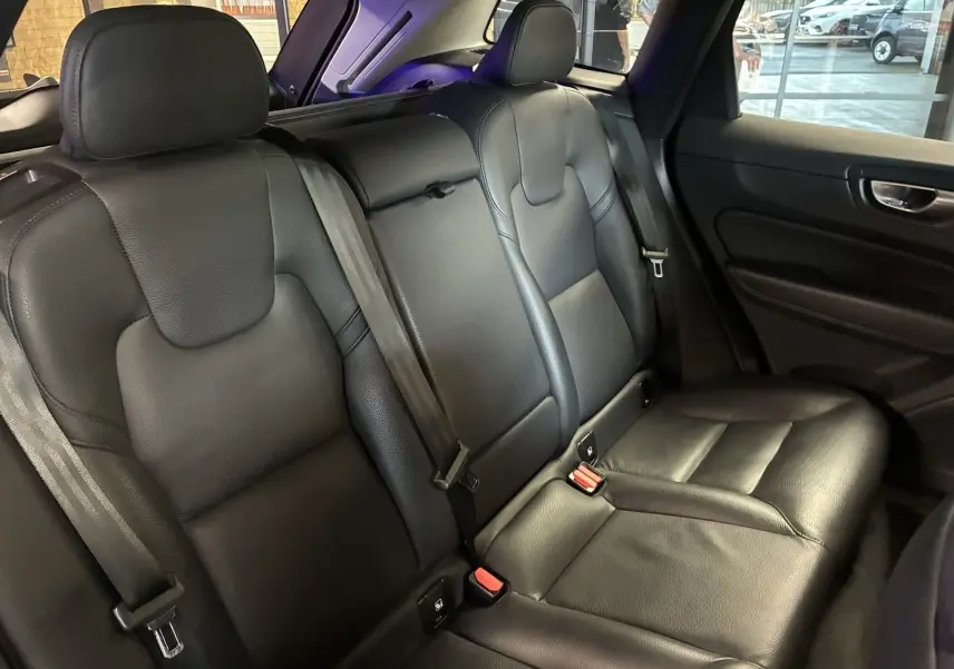 Vue intérieure côté droit des sièges arrière en cuir noir du Volvo XC60 2023, avec ceintures et appuis-tête visibles.