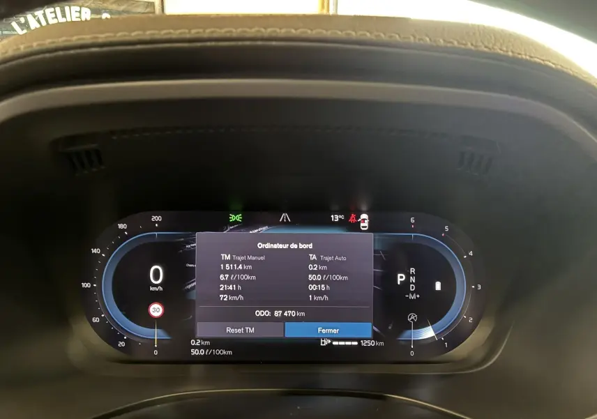 Tableau de bord numérique du Volvo XC60 bleu 2023 affichant l'ordinateur de bord et les compteurs digitaux.