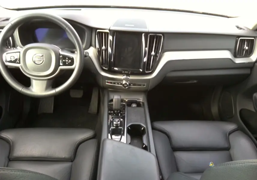 Vue latérale droite d'un Volvo XC60 bleu 2023 avec jantes alliage 20'' bicolores et rétroviseurs noirs laqués.