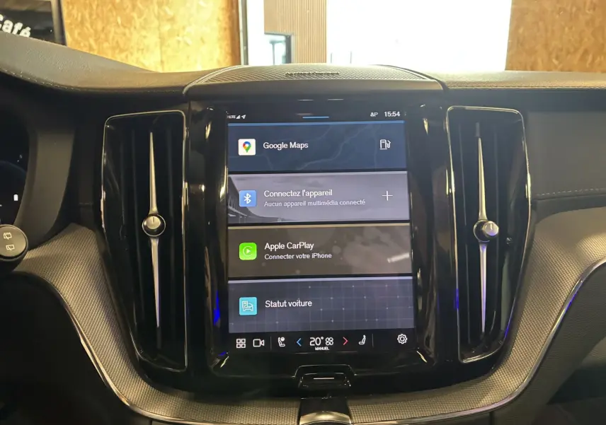 Écran tactile central du tableau de bord du Volvo XC60 2023 avec finition noir laqué et inserts texturés.