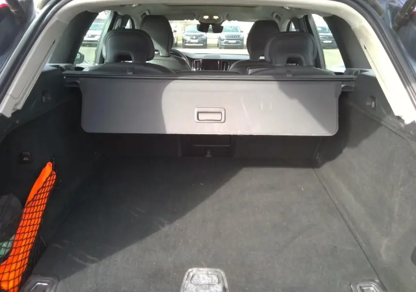 Vue 3/4 arrière droite du Volvo XC60 bleu 2023 avec feux arrière LED et jantes alliage 20 pouces noir diamant.