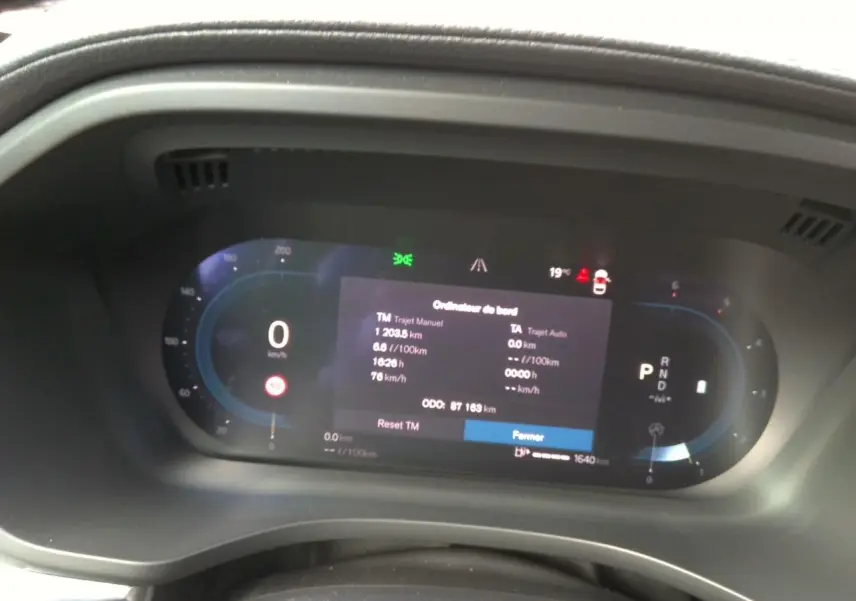 Vue latérale droite d'un Volvo XC60 bleu 2023 avec jantes alliage 20'' noir et diamant dans un garage.