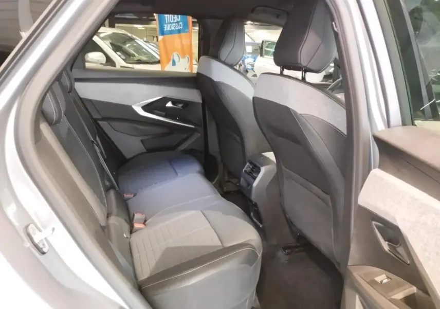 Vue intérieure côté gauche des sièges arrière en tissu gris et noir du Peugeot 3008 2024 hybride, avec port USB central visible.