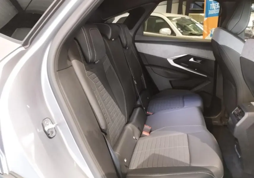 Vue intérieure côté gauche des sièges arrière en tissu et cuir noir du Peugeot 3008 gris Artense, avec détails de la porte et console centrale.