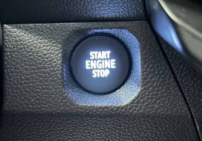 Bouton Start Engine Stop en gros plan sur le tableau de bord noir du Dacia Duster TCE 130 4x4 Extreme 2024.