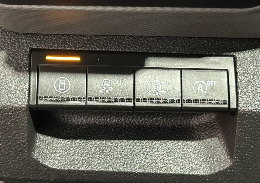 Gros plan sur les boutons de commande du tableau de bord du Dacia Duster 2024, finition Sandstone.