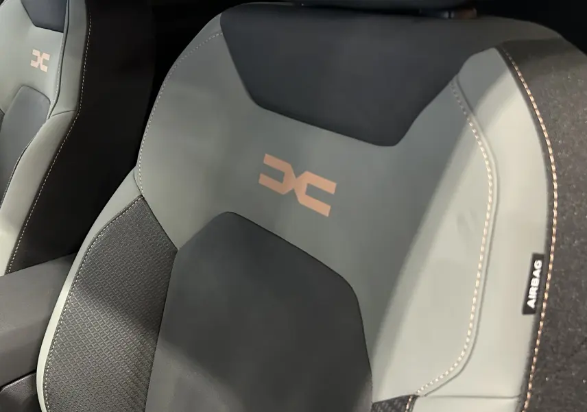 Gros plan sur le siège avant du Dacia Duster 2024 TCE 130 4x4 Extreme en tissu noir et gris avec logo DC brodé.