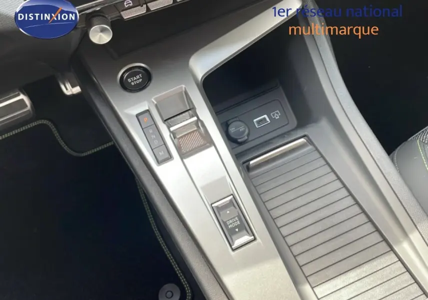 Gros plan sur la console centrale de la Peugeot 308 hybride 2026, avec levier de vitesses automatique et bouton start/stop.