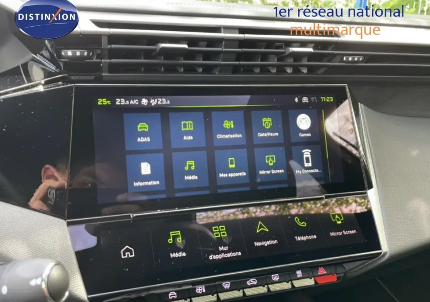 Vue rapprochée de l’écran tactile central du tableau de bord de la Peugeot 308 gris Artense, affichant les menus multimédias et climatisation.