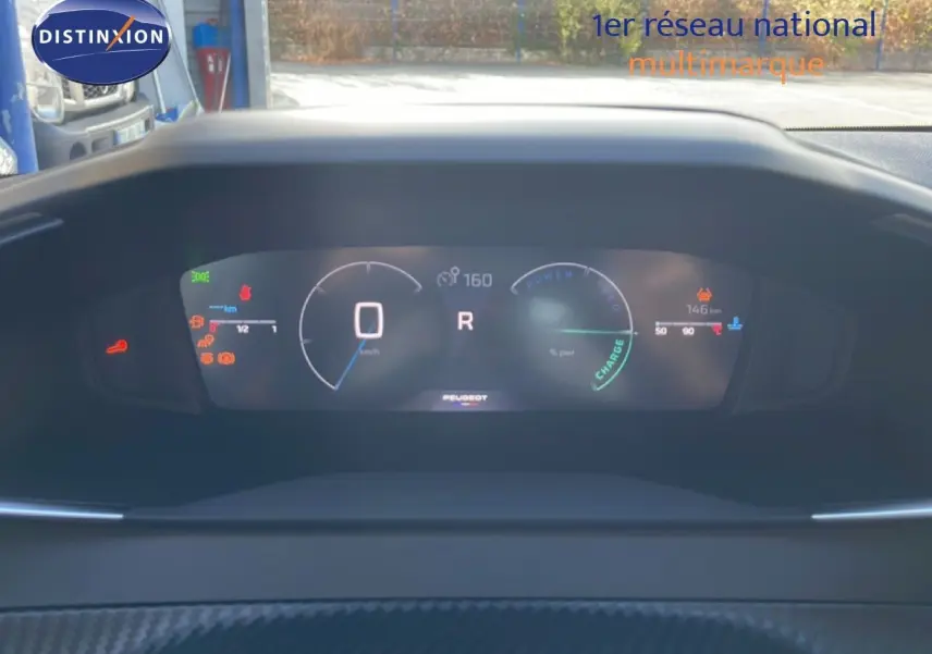 Vue du tableau de bord numérique de la Peugeot 208 Hybrid blanc Okenite, affichant la vitesse et l'autonomie.