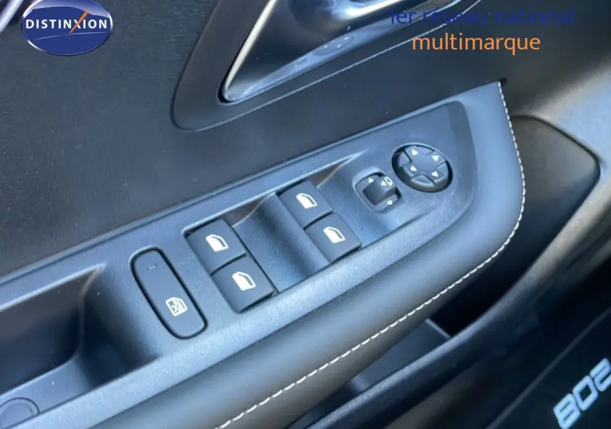 Gros plan sur la commande des vitres électriques côté conducteur de la Peugeot 208 Hybrid blanche, avec surpiqûres blanches.