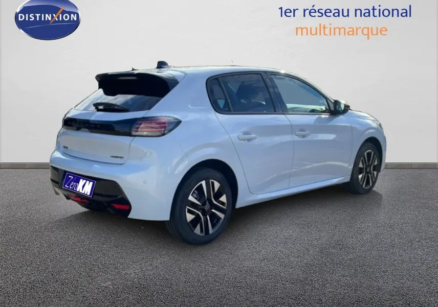 Vue 3/4 arrière droite d'une Peugeot 208 hybride blanche Okenite Metal avec jantes noires et détails noirs contrastants.