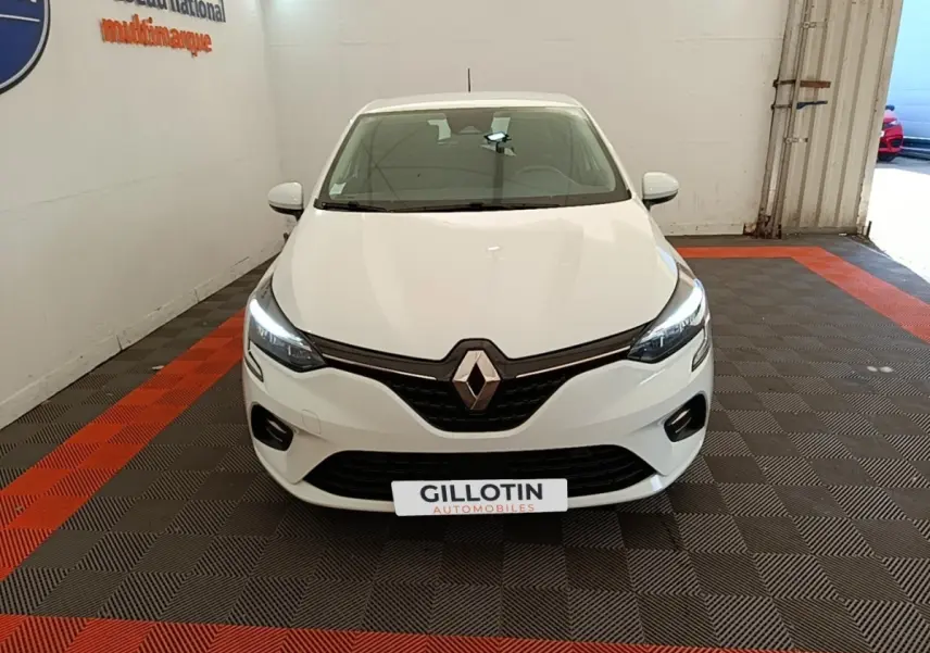 Renault Clio Business E-TECH 140 blanc vue de face, phares LED allumés dans un garage.