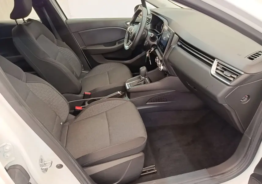 Intérieur de la Renault Clio Business E-TECH 140 blanc, vue côté conducteur montrant sièges et tableau de bord moderne.