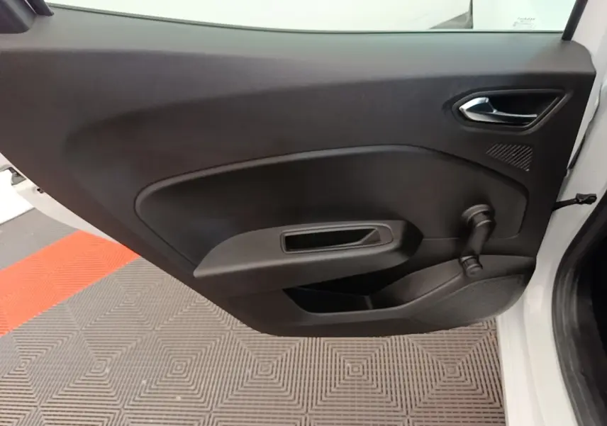 Vue intérieure de la porte avant droite d'une Renault Clio blanche, avec poignée et manivelle de vitre noire.