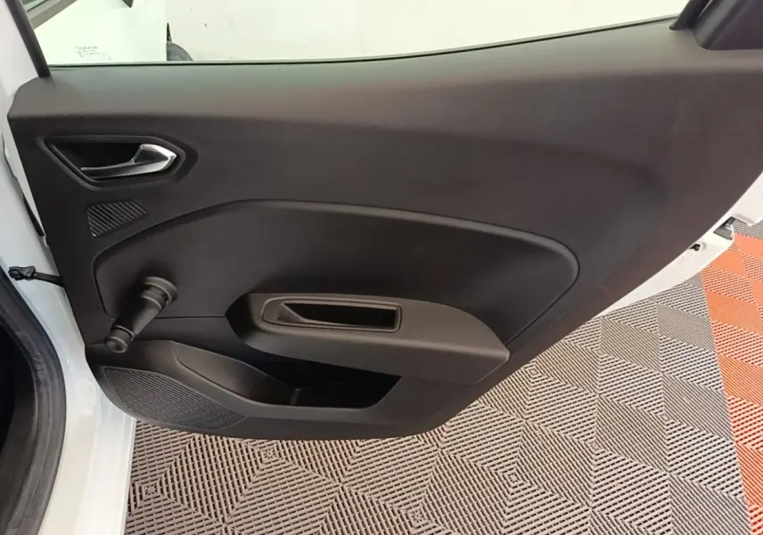 Vue intérieure de la porte arrière gauche blanche de la Renault Clio Business E-TECH 140 avec poignée manuelle de vitre.