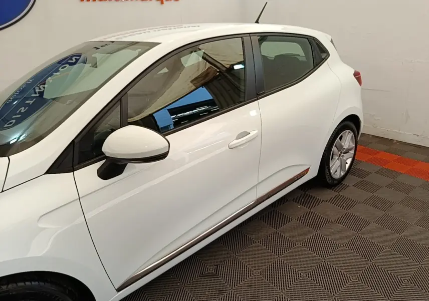 Profil côté gauche de la Renault Clio Business E-TECH blanche 2021 avec rétroviseur et jante visibles.